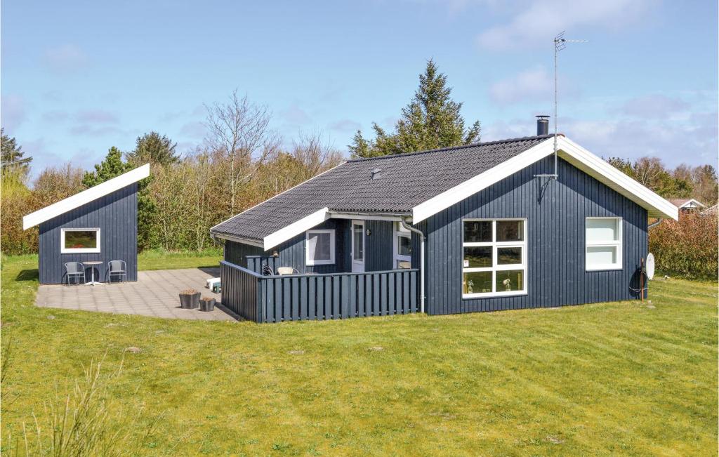 Sønder NissumにあるAwesome Home In Ulfborg With 3 Bedrooms And Wifiの庭付青い家