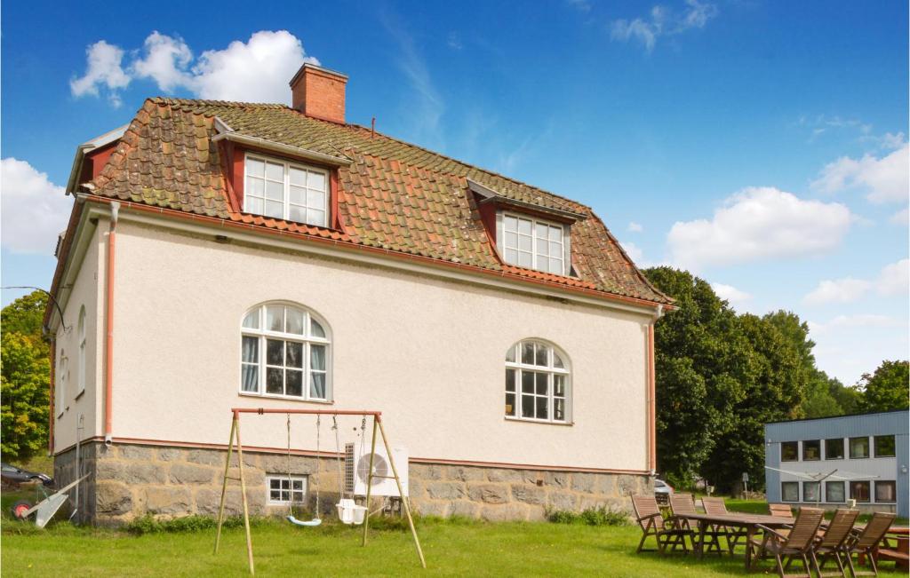 Gorgeous Home In Finspng With Wifi في Finspång: منزل قديم أمامه طاولة نزهة