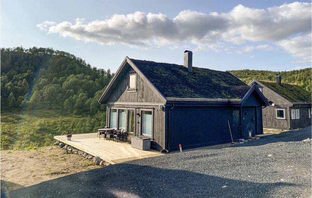 una pequeña casa azul con terraza de madera en Pet Friendly Home In Rauland With House A Mountain View, en Rauland