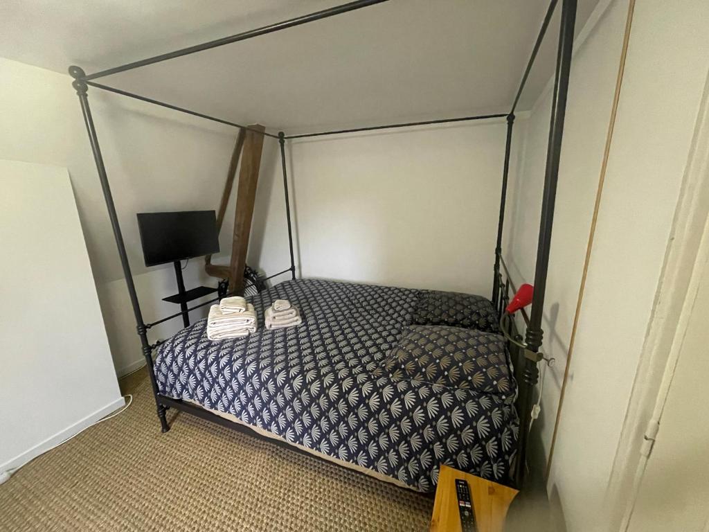 努瓦永的住宿－Chambre privée cosy，一间卧室配有一张带天蓬的床
