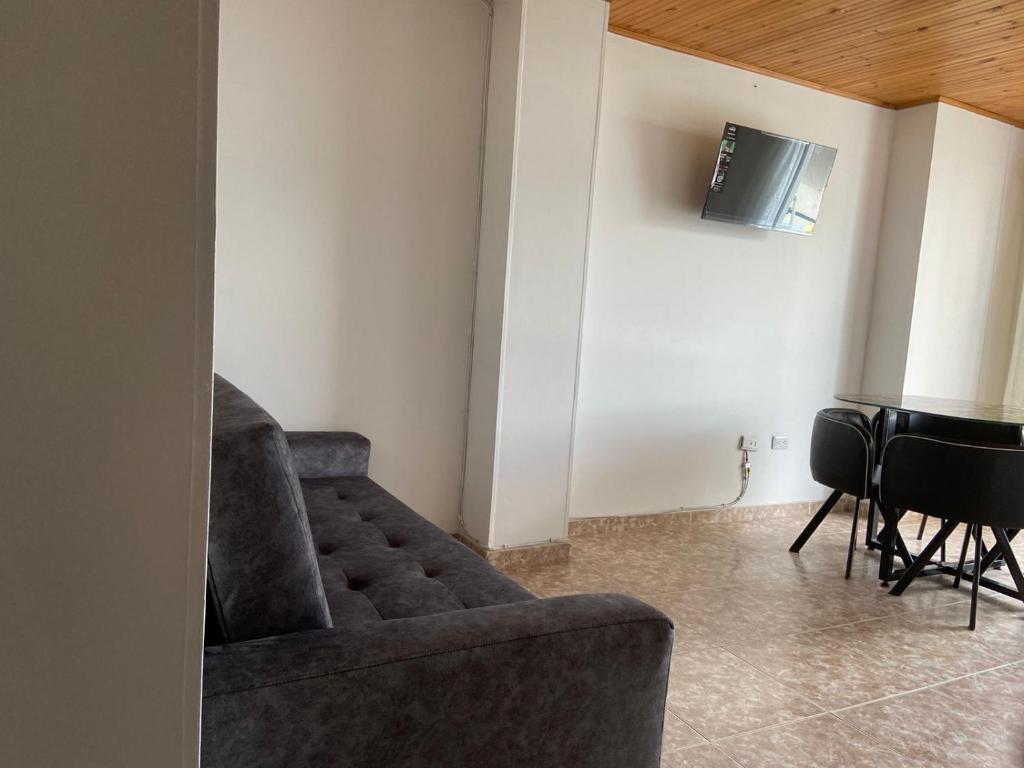 sala de estar con sofá y TV en Acogedor Apartamento céntrico I, en Armenia