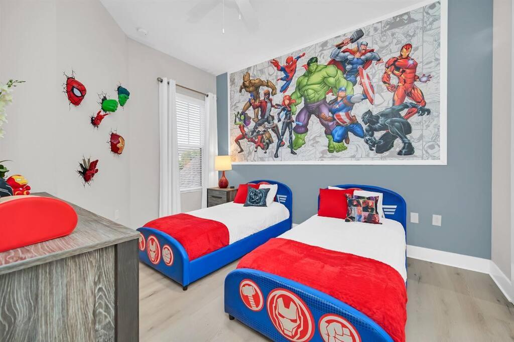 a bedroom with two beds and a marvel mural at Magical Residence Resort, 5 min Disney in Orlando