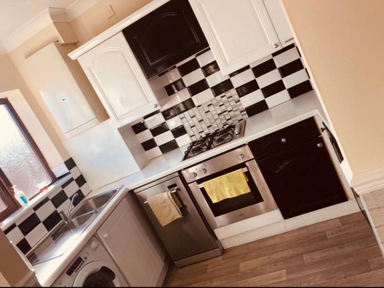 una cocina con azulejos blancos y negros en la pared en AC Lounge 36 (Room D), en Rochford
