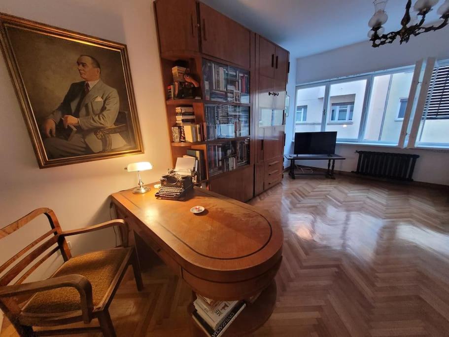 a living room with a table and a picture of a man at HelloZagreb Apartment in Zagreb