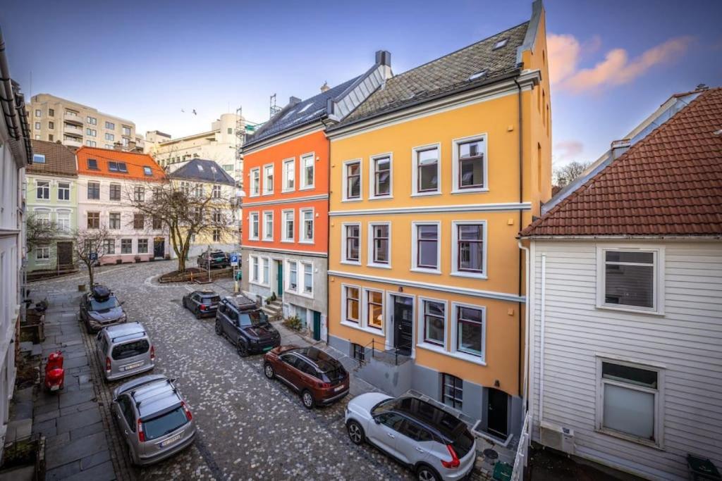 uma rua da cidade com carros estacionados em frente aos edifícios em Dinbnb Apartments I New 2023 I 600m to Bryggen em Bergen