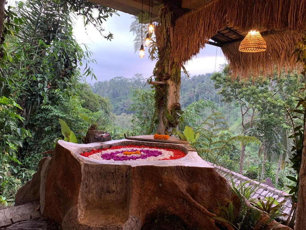ein Zimmer mit einem Tisch mit Blumen darauf in der Unterkunft Bali Inang Jungle View in Tampaksiring