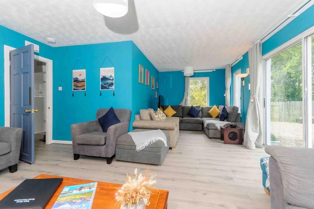 a living room with blue walls and a couch and chairs at Stunning House near Fort William - Taigh Sona in Spean Bridge