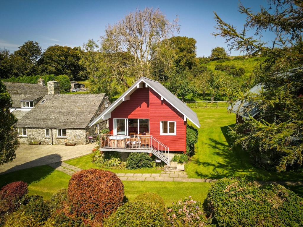 una casa roja en medio de un patio en Ta Mill Cottages & Lodges - Meadowview Chalet 1 en Launceston