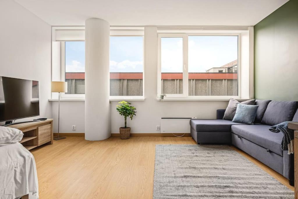 sala de estar con sofá, TV y 2 ventanas en Dinbnb Apartments I Top-Modern Apartment in Historical Sandviken en Bergen