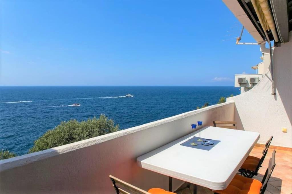 einen weißen Tisch und Stühle auf einem Balkon mit Meerblick in der Unterkunft Light blue, sea view terrace in Dubrovnik
