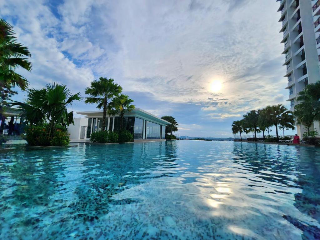 una piscina con un edificio y palmeras en D'Hive By Tiara Imperio en Kajang