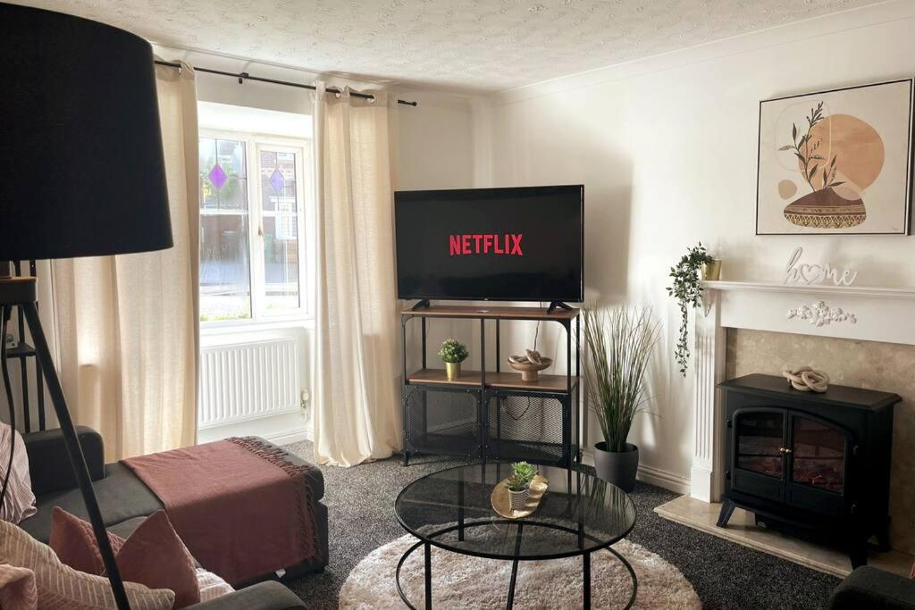 ein Wohnzimmer mit einem TV und einem Kamin in der Unterkunft Ramson's Homestead by M-GroupSA in Cardiff