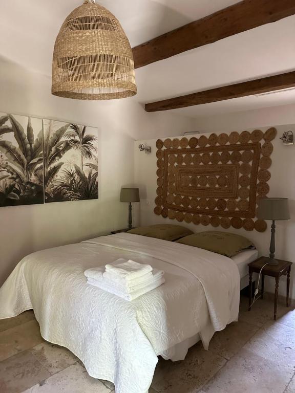 ein Schlafzimmer mit einem großen Bett und einem Kronleuchter in der Unterkunft Mas au Paradou in Paradou