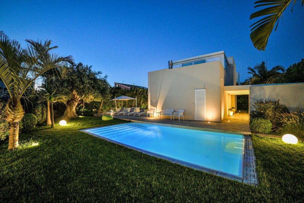 een huis met een zwembad in de tuin bij Villa Ponente - Design House with Private Pool in Marina di Ragusa