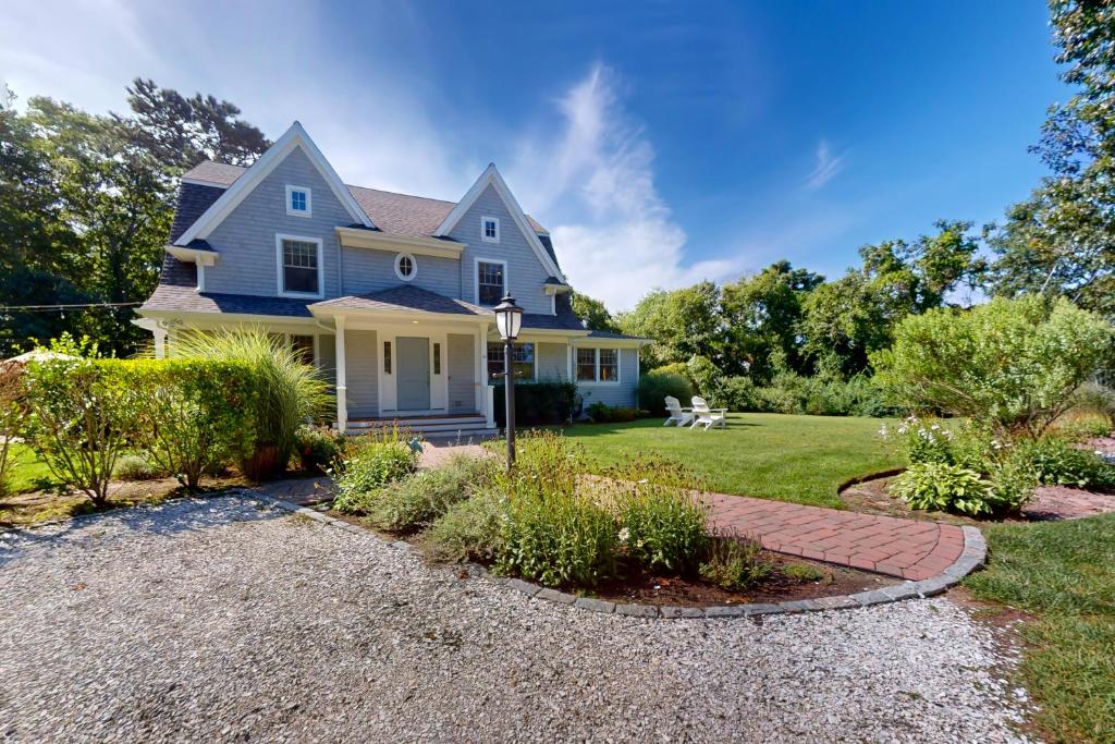 a blue house with a gravel driveway at Lewis Bay Getaway in West Yarmouth