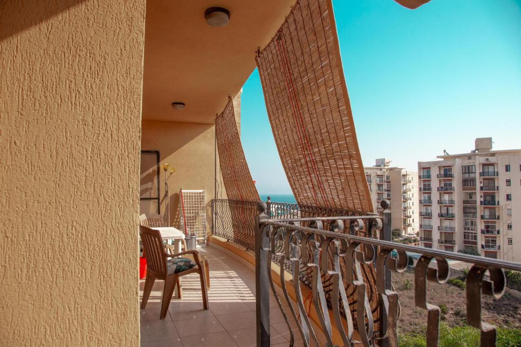 - un balcon avec des chaises et une table dans un bâtiment dans l'établissement 2BD Cosy Apartment with Spacious Balcony - Close to Bugibba Beach, à San Pawl il-Baħar