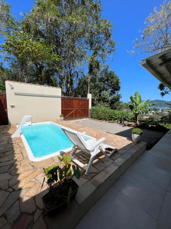 烏巴圖巴的住宿－Vista pro mar，庭院内一个带躺椅和椅子的游泳池