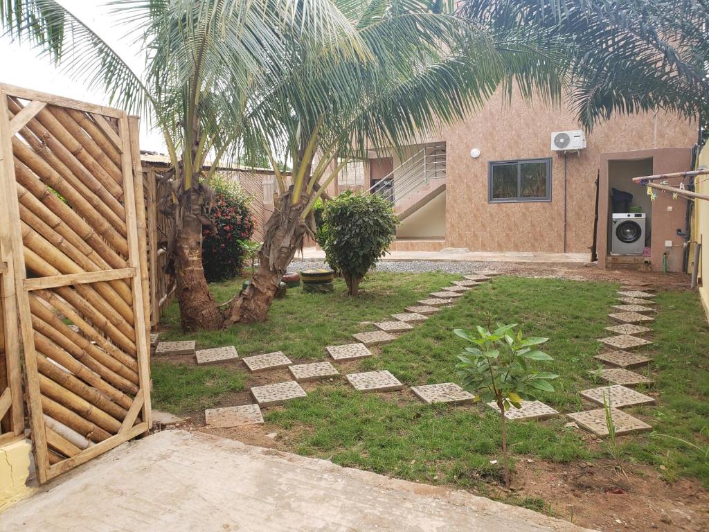 a garden with a wooden gate and a fence at Fafape in Lomé
