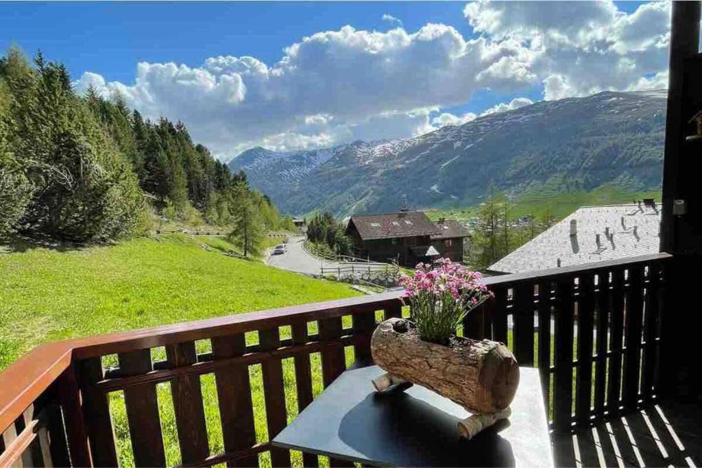 a bench on a balcony with a view of a mountain at Livigno Vista panoramica .Casa. in Livigno