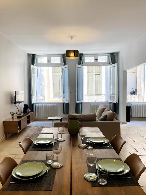 un salon avec une table et un canapé dans l'établissement Grand T3 rénové climatisé - Coeur de Montpellier, à Montpellier
