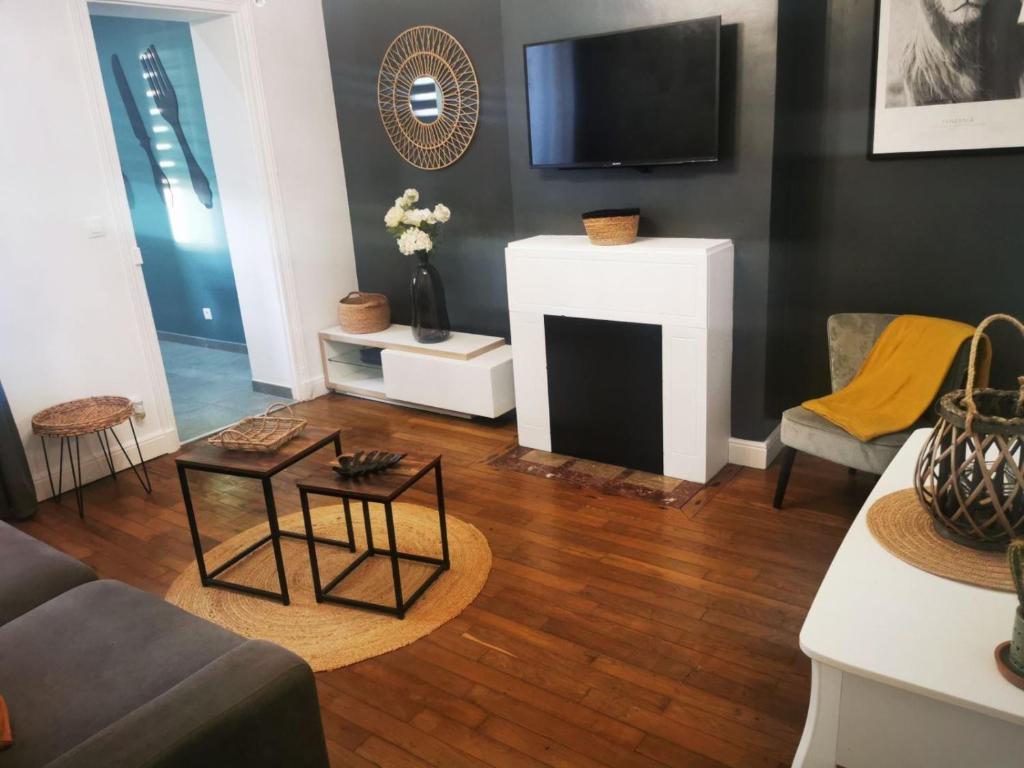 sala de estar con chimenea y TV en Le Cocon d'Aurore, en Reims