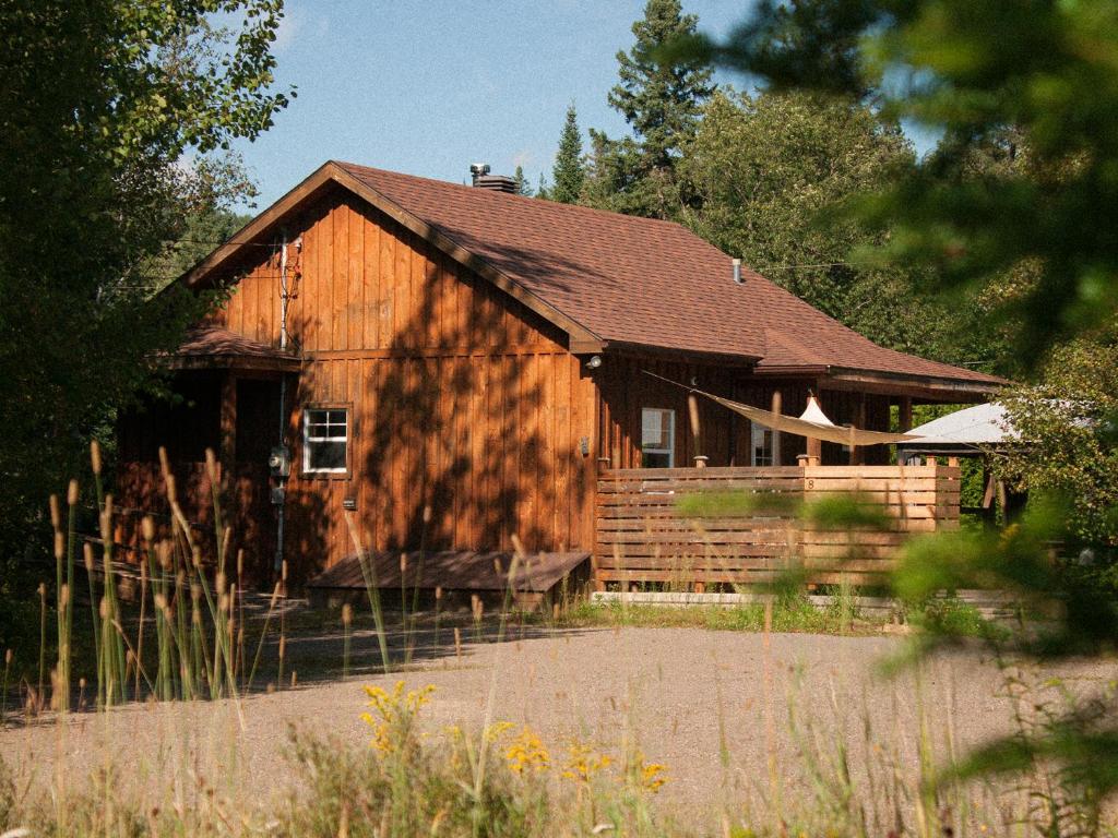 une grande grange en bois avec une clôture devant elle dans l'établissement Chalet 8, à Val-David