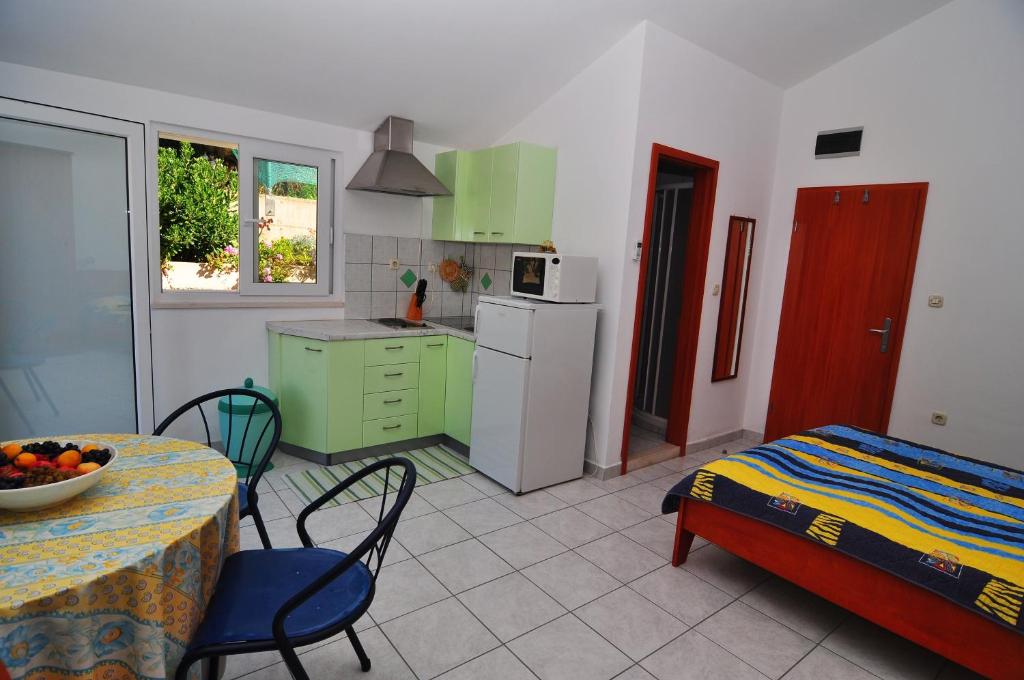 kuchnia ze stołem i łóżkiem oraz stołem i krzesłami w obiekcie Apartments Livia w mieście Lastovo