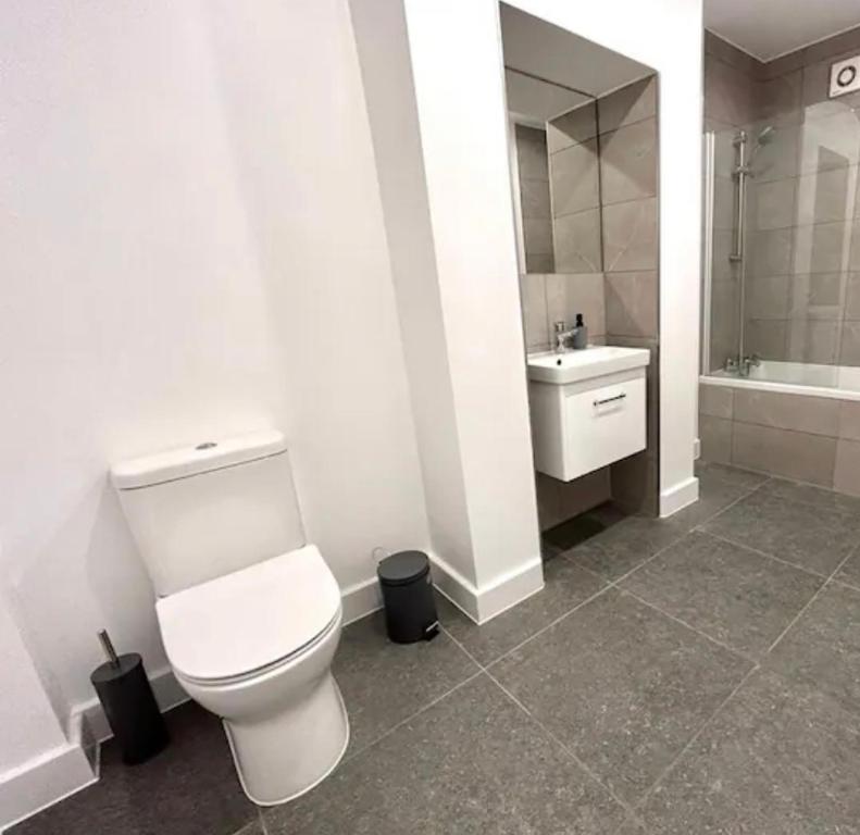 y baño con aseo blanco y lavamanos. en 2 Bedroom Luxury Appartment en Finchley