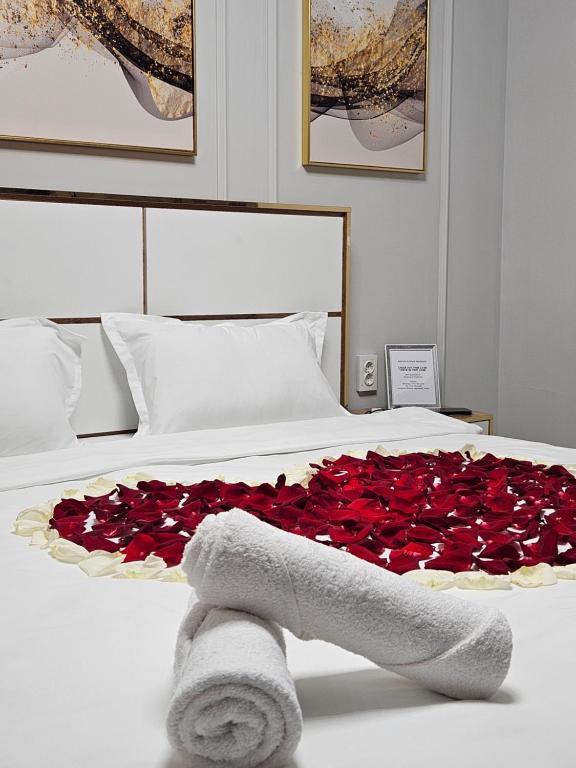 Una cama con un montón de rosas rojas. en DeLuxe Apartments en Almaty