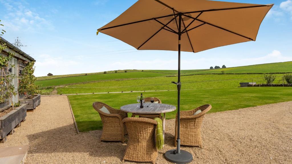 a table and chairs with an umbrella on a patio at Griffedale in Brassington