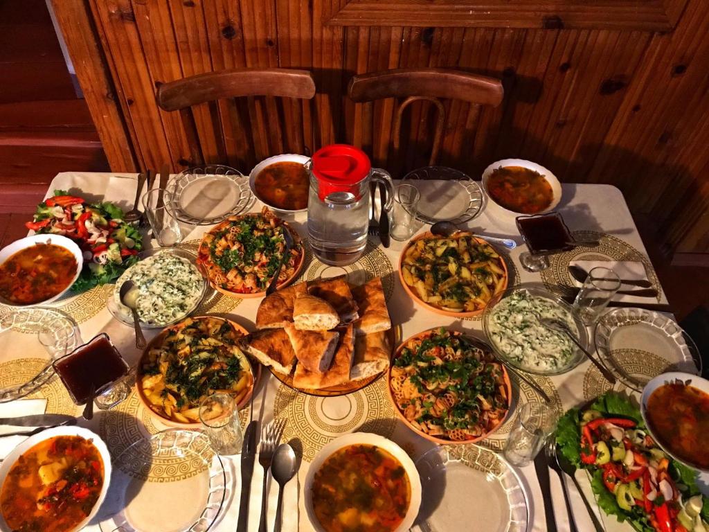 a table topped with lots of different types of food at Tsvirmi Zviadi's guesthouse in Mestia