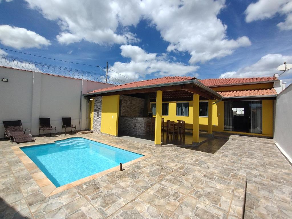 a house with a swimming pool in a yard at Pouso Oliveira Casa com ar condicionado in São João Batista do Glória