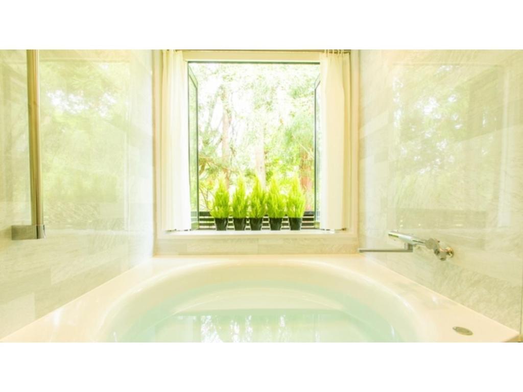 a bath tub in a bathroom with a window at Restaurant & Hotel Traumerei - Vacation STAY 47795v in Hakuba