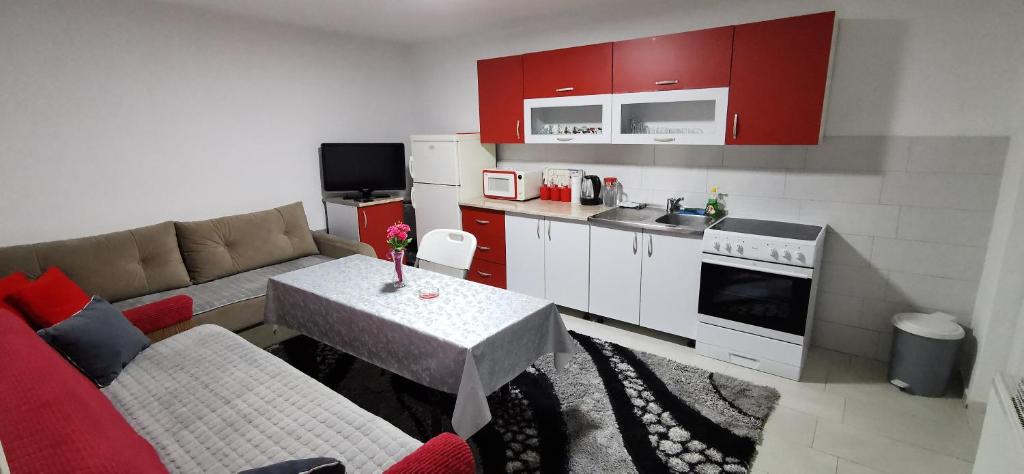 ein Wohnzimmer mit einem Sofa und einem Tisch in der Küche in der Unterkunft Apartman Delic in Lukavac
