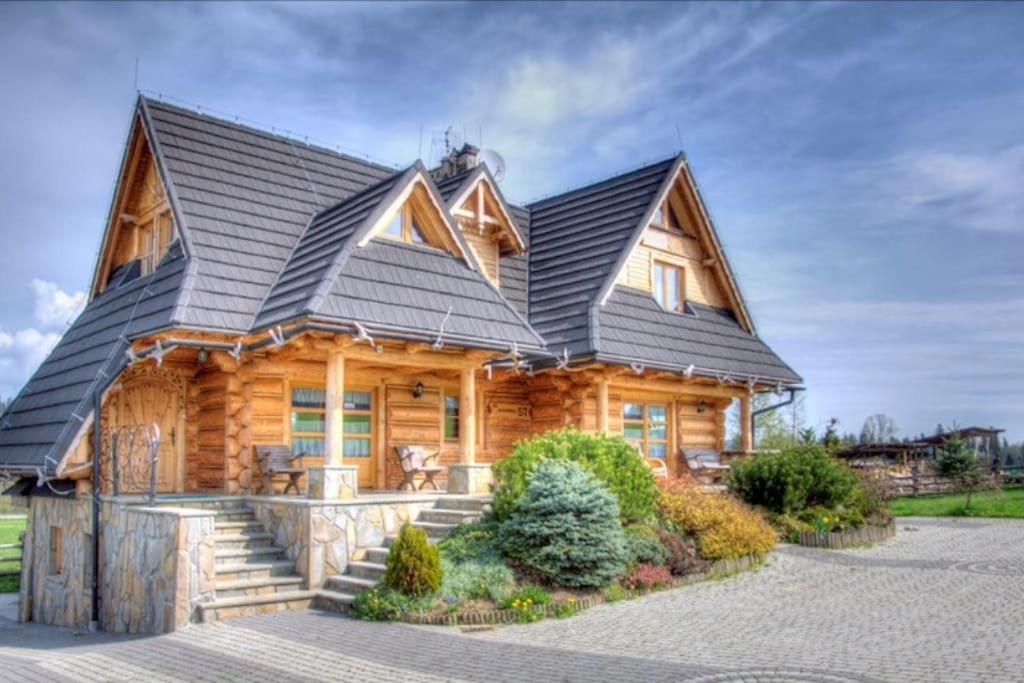 a log cabin with a black roof at Domki u Marii- agroturystyka in Bańska Niżna