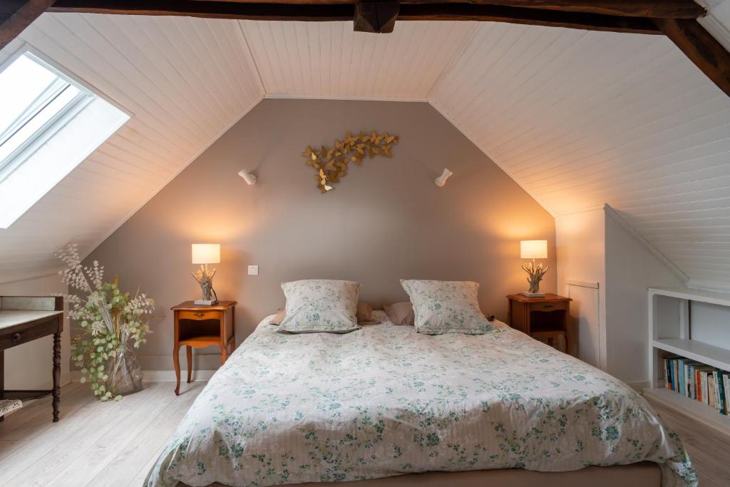 een slaapkamer met een bed met 2 kussens erop bij LES DEUX RIVIERES - Chambres & Table d'Hôtes - in Le Faouët