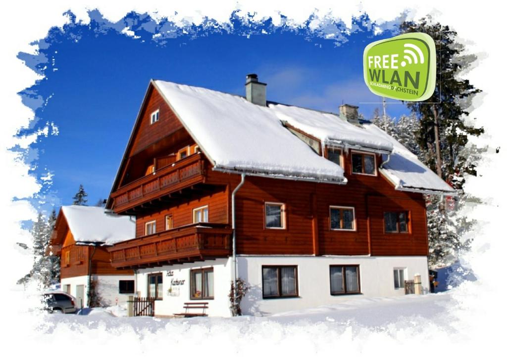 a house in the snow with a free man sign on it at Haus Kartoner in Schladming