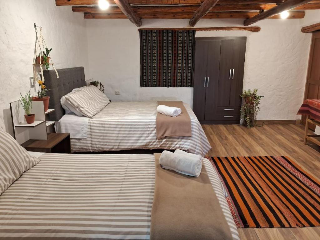 a bedroom with two beds and a closet with a door at KOSKO Casa Hotel in Cusco