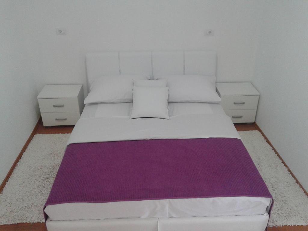 sypialnia z dużym łóżkiem i 2 szafkami nocnymi w obiekcie Apartmani i sobe Milojević w mieście Trebinje