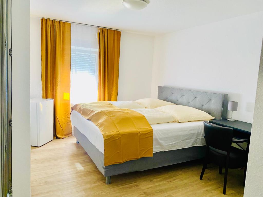 a bedroom with a bed and a desk with a chair at Hotel SuvaNa 