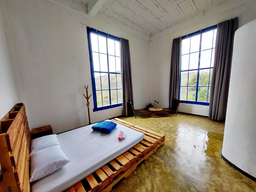 um quarto com uma cama grande e 2 janelas em Suíte Senhor de Engenho em Nova Lima