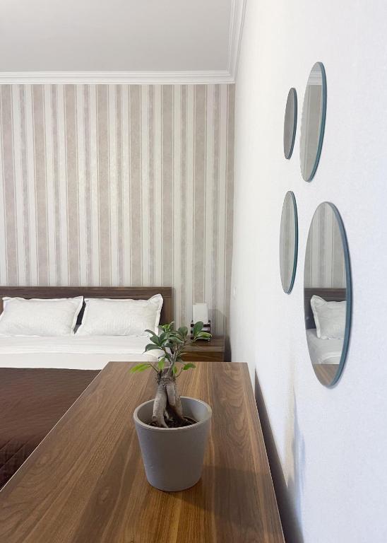 a bedroom with a bed and a table with a potted plant at Guest House on Meskheti in Borjomi
