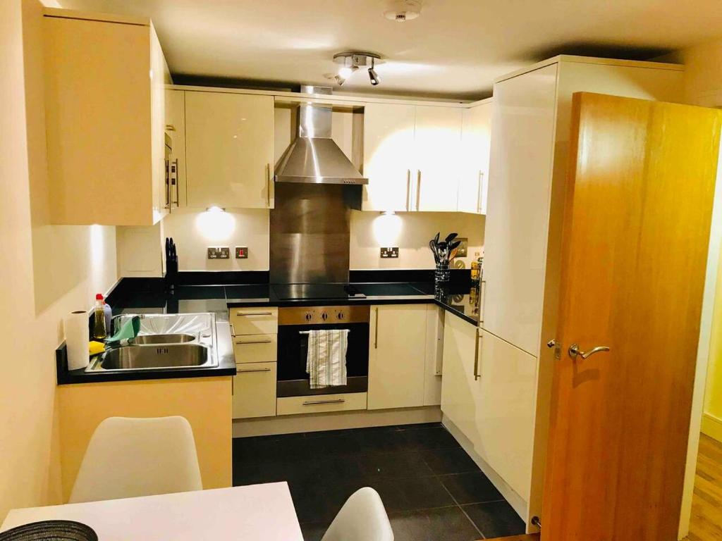 a kitchen with a sink and a stove top oven at Modern apartment moments from Shoreditch in London