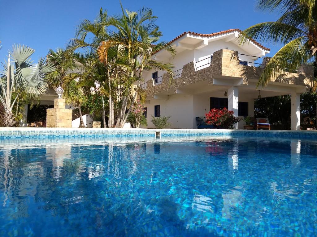 una grande piscina di fronte a una casa di Villa Cocuyo Studios a El Cardón