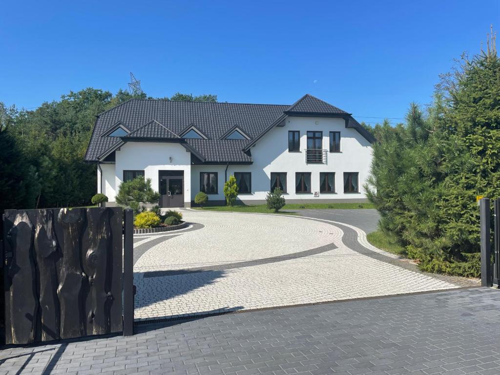 a large white house with a winding driveway at Zakątek przy lesie 