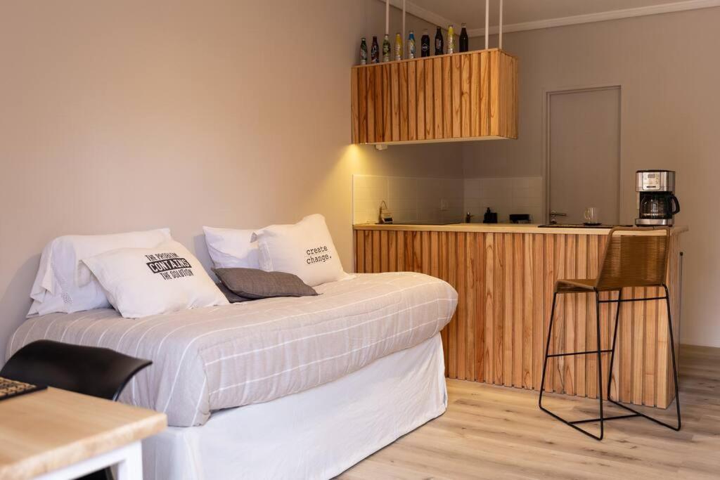 1 dormitorio con 1 cama con almohadas blancas y cocina en Azcuenaga 2862 by depptö en Martínez