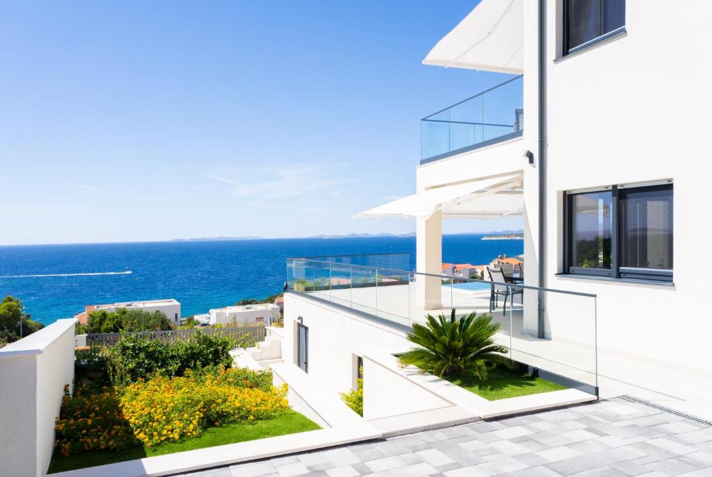 a white house with a view of the ocean at Villa Infinity View in Primošten