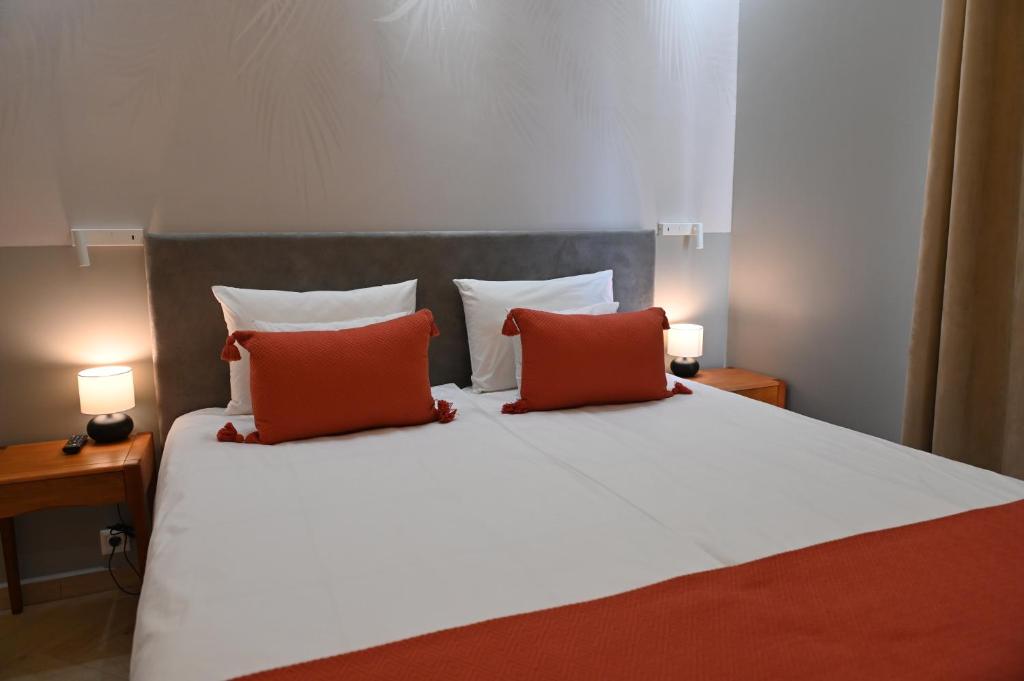 1 dormitorio con 1 cama con 2 almohadas rojas en H49 Jacuzzi Penthouse-Adults only, en Sovata