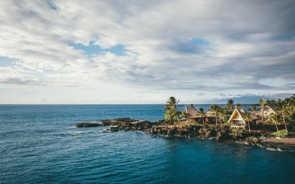 凱魯瓦的住宿－Kona Village A Rosewood Resort，海中的一个岛屿,有房子和树木
