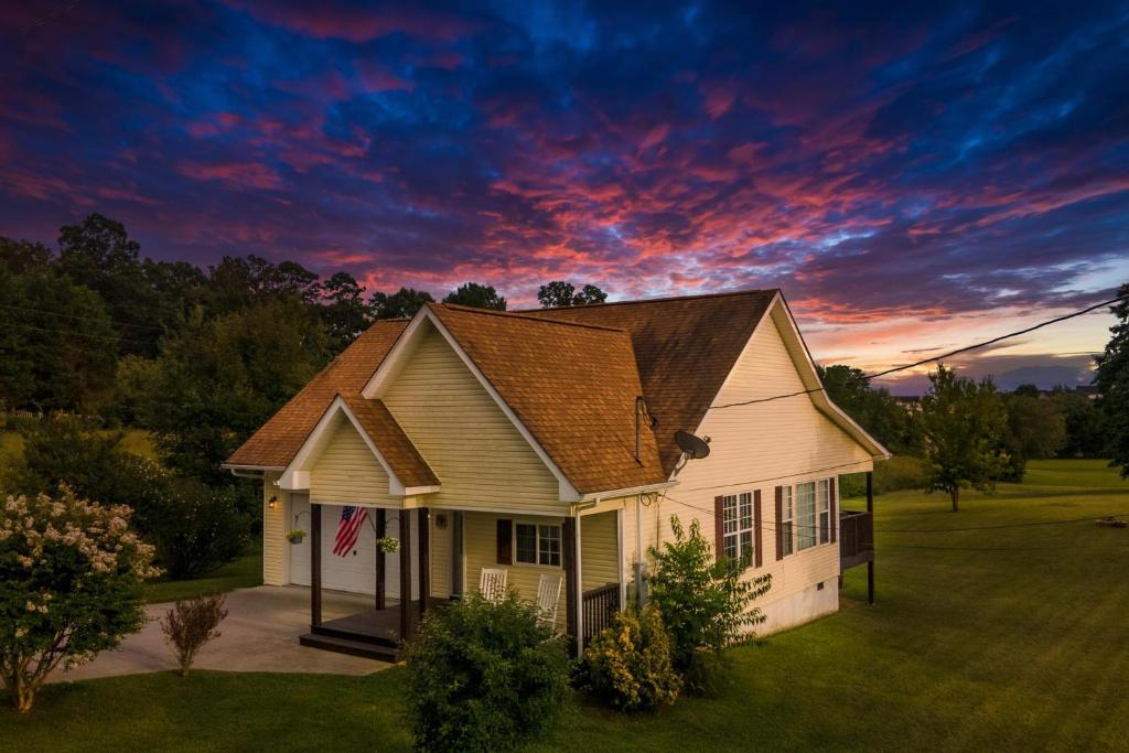 Ein Haus mit Sonnenuntergang am Himmel in der Unterkunft Charming Family Country Lane Cottage 3 min to lake in Dandridge